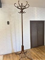 Full view of the wooden coat rack showing hooks and base