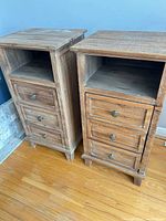 Two wooden end tables showing fronts with open shelves and drawers