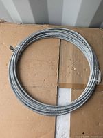 Full view of coiled steel wire rope on cardboard surface