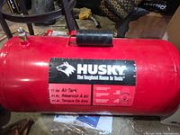 Full view of red Husky 11 gal air tank with handle