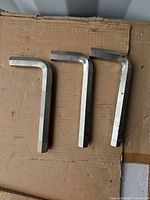 Three large L-shaped hex keys on cardboard