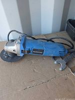 Overall view of blue Mastercraft angle grinder with disc and wrench