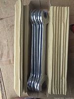 Five chrome wrenches nested in original corrugated cardboard sleeve