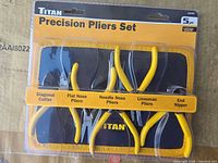 Front view of sealed Titan 5-piece precision pliers set showing all five tools and label