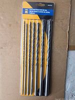 Front view of sealed 7-piece brad point drill bit set showing all bits