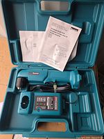 Open case showing angle drill, charger, manuals, molded compartments