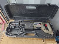 Saw inside opened case showing overall tool and cord