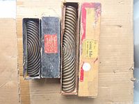 Four antique graining rollers in boxes on cardboard