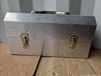 Front view showing hinged lid, latches, handle