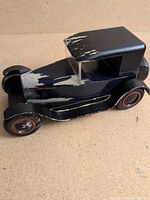 Full view of black wooden toy car showing size and general condition