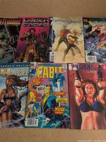 Seven comic books laid out showing covers