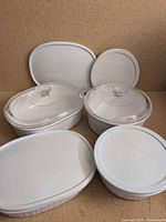 Group of CorningWare dishes with glass and plastic lids displayed