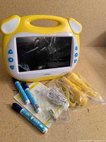 Front view of yellow kids learning tablet with accessories