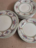 Three stacks of floral rim plates, two sizes visible