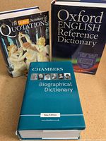 Three hardcover dictionaries standing upright showing front covers
