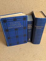 Three blue hardcover books together: Cruden’s Complete Concordance, Halley’s Bible Handbook, Redemption Songs