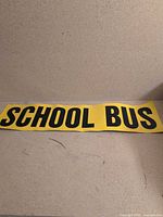 Full view of yellow magnet sign displaying "SCHOOL BUS" text
