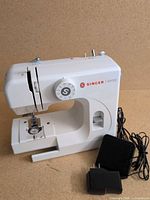 Front and side view of sewing machine with foot pedal and power adapter