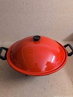 Red electric wok with lid on view
