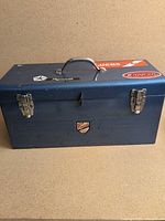 Front view of blue Beach toolbox showing handle and stickers