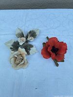 Both porcelain floral figurines side by side