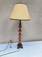 Full view of table lamp showing shade, ceramic spheres, base, cord