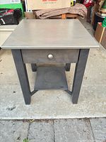 Front view of night table showing drawer, knob and lower shelf