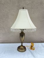 Full view of brass lamp with shade and cord