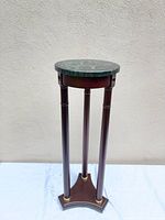 Full view of pedestal plant stand showing marble top, wood legs, brass accents