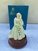 Front view of figurine on wooden base with box