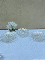 Four iridescent glass sunburst bowls displayed upright and flat