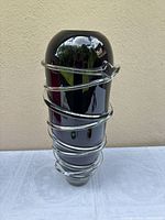 Front view of tall black vase with clear spiral wrap