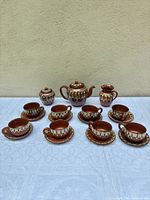 Full 20-piece tea set arranged: teapot, sugar with lid, creamer, 8 cups, 8 saucers