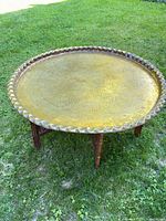 Full view of brass tray table on grass