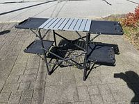 Wide view of entire foldable camp kitchen showing slat top, side shelves, wire rack