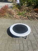 Full view of round trampoline on pavement