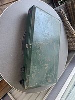 Stove closed showing exterior wear on green case