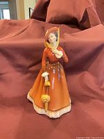 front view of figurine showing full attire and parasol