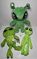 Front view of all three alien plush toys