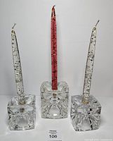 front view of three cube glass holders each with a lucite candle inserted