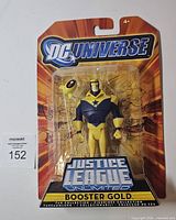 Front view of sealed Booster Gold figure on card