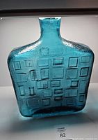 Front view of aqua blue Empoli glass bottle showing brick texture