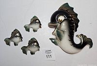 All four ceramic fish plaques with lot tag visible