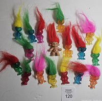 Group of 18 mini troll figures arranged on white background showing colours and hair styles