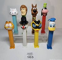 Front view of eight PEZ dispensers standing upright