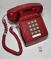 complete red touch-tone telephone with handset and keypad visible