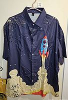 Front view of navy shirt with rocket launch graphic