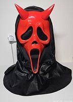 Front view of red devil mask with black hood