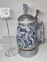 Front view of ceramic space stein showing astronaut relief and number marker