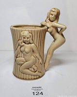 Front view of ceramic stein with raised nude figure and ribbed body